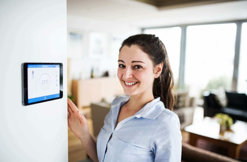 Woman standing by her smart thermostat
