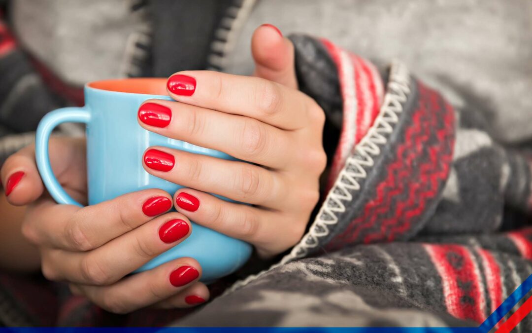 person holding a coffee cup while in a blanket