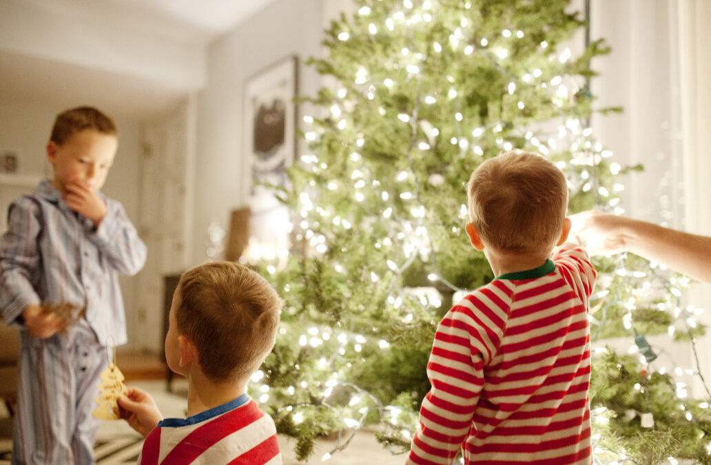 Young children around the christmas tree during the holidays and kept warm by a functioning HVAC unit